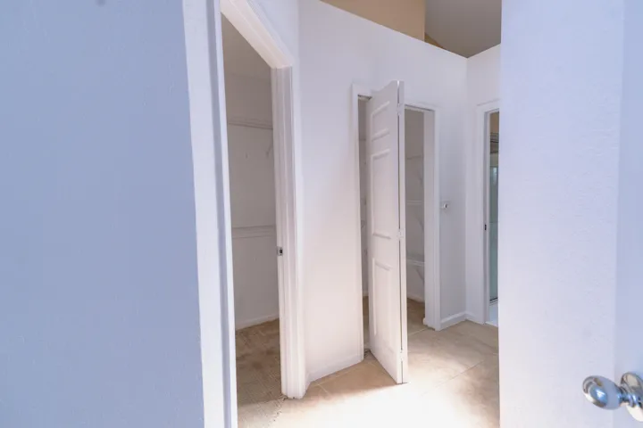 Multiple entryways with white paneled doors, light tile flooring, and carpeted interior spaces