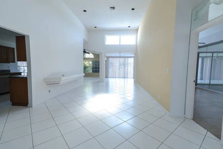 High ceilings, recessed lighting, and white tile flooring
