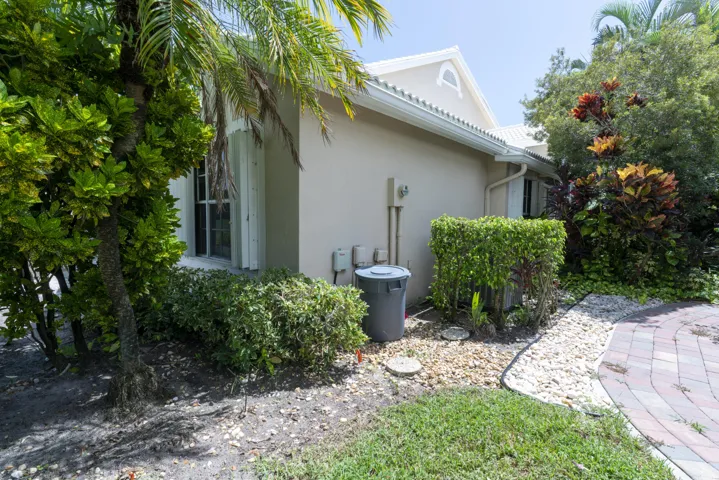 Exterior stucco siding with a gabled roofline and white gutters