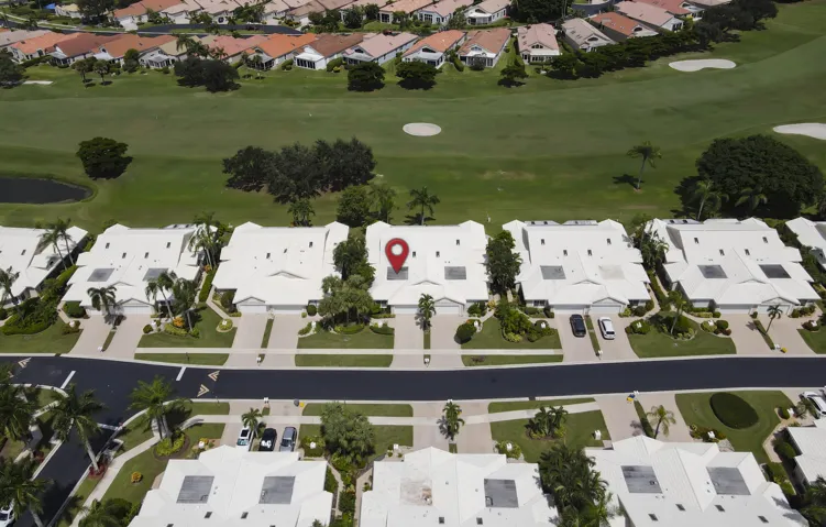 Aerial perspective of multiple properties bordering a manicured golf course
