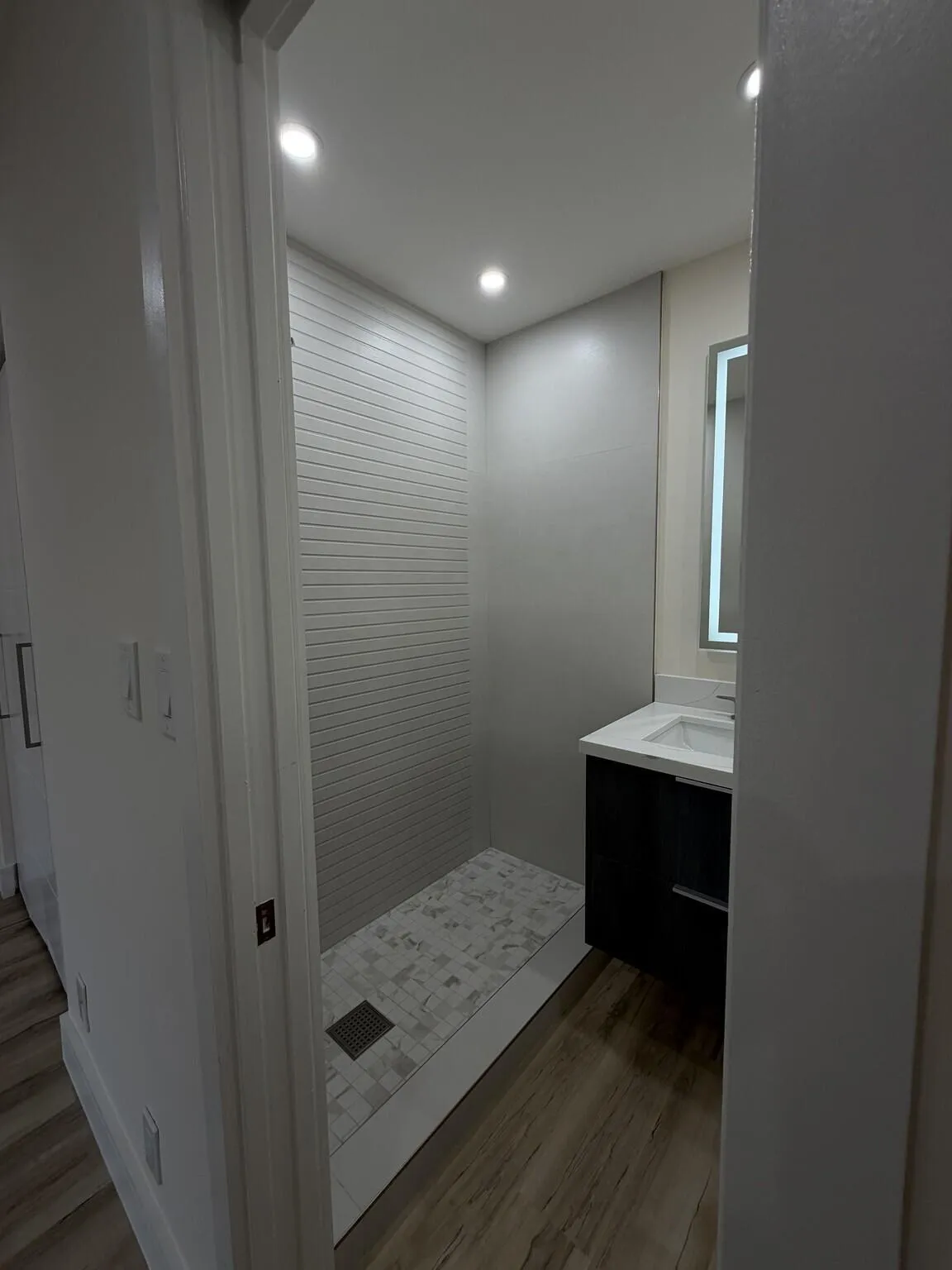 Walk-in shower with horizontal tile surround and tiled floor