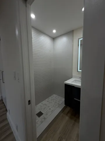Walk-in shower with horizontal tile surround and tiled floor