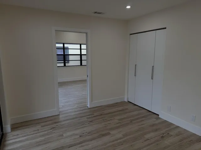 Wood-finish flooring, recessed ceiling lighting, and a bi-fold closet with contemporary hardware