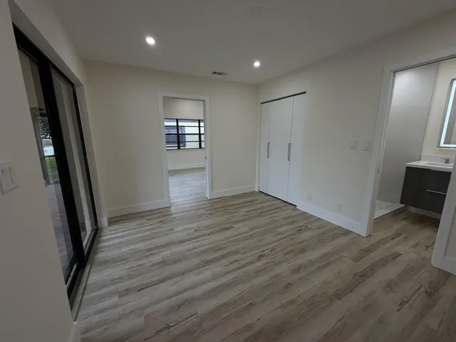 Wood-finish flooring throughout, recessed lighting, and a sliding glass door