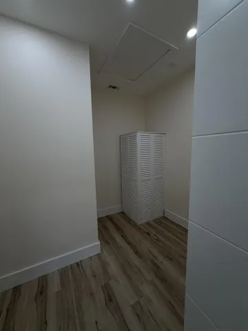 Recessed ceiling lighting illuminates wood-finish flooring