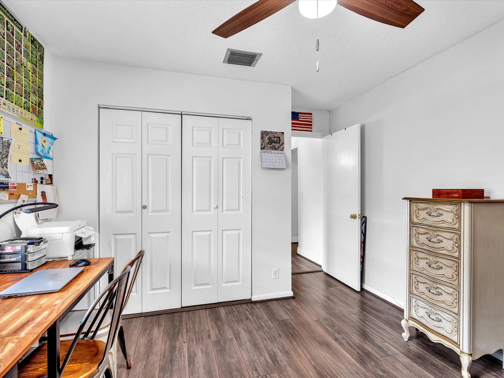 Wood-finish flooring, white walls, and a ceiling fan