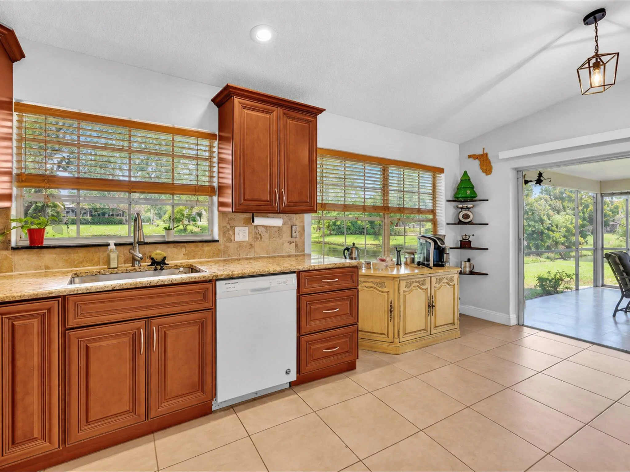 Kitchen featuring wood-finish cabinetry, light-toned tile flooring, and a stone-finish countertop