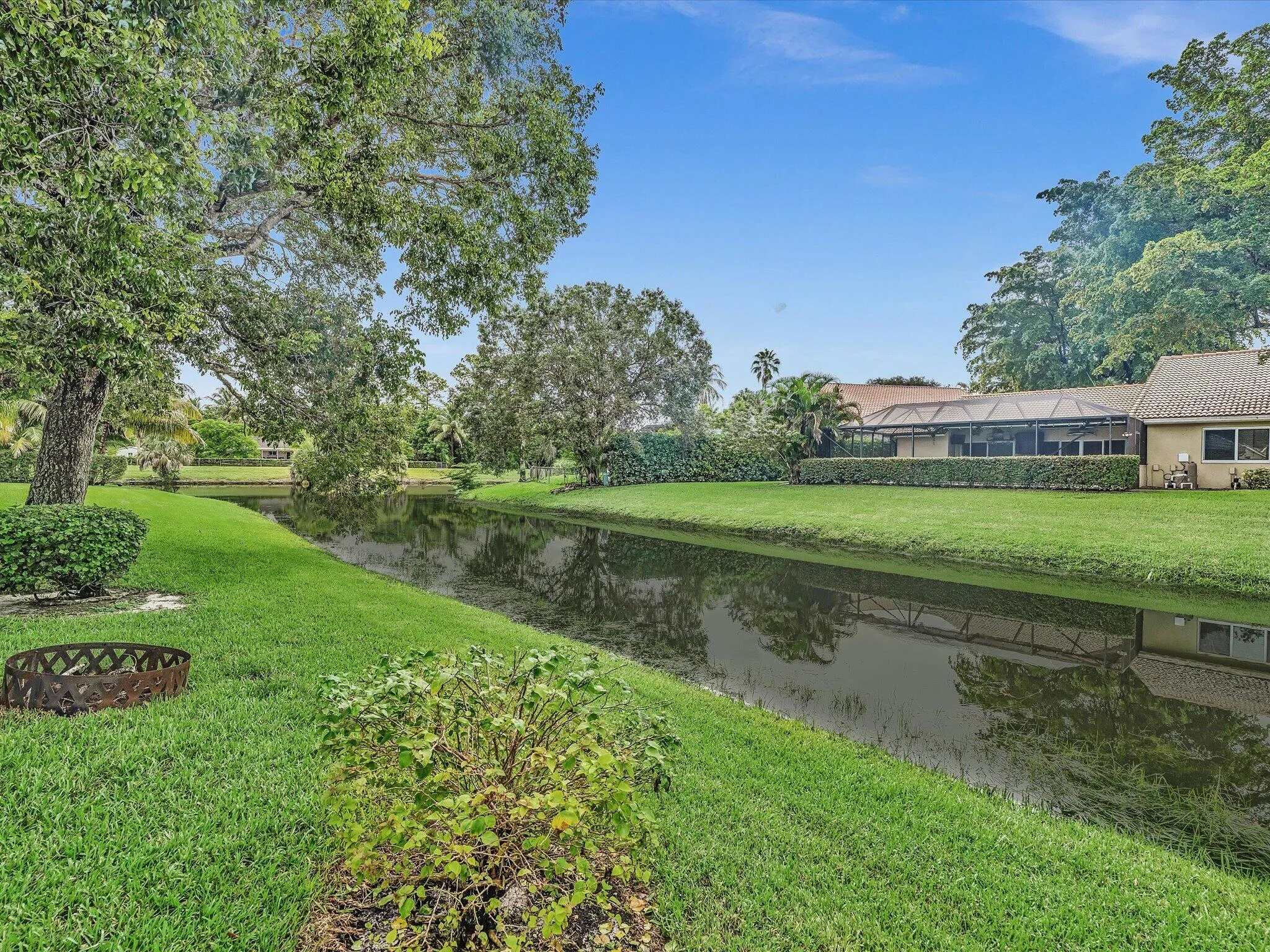 Lush green lawn with mature trees and canal frontage