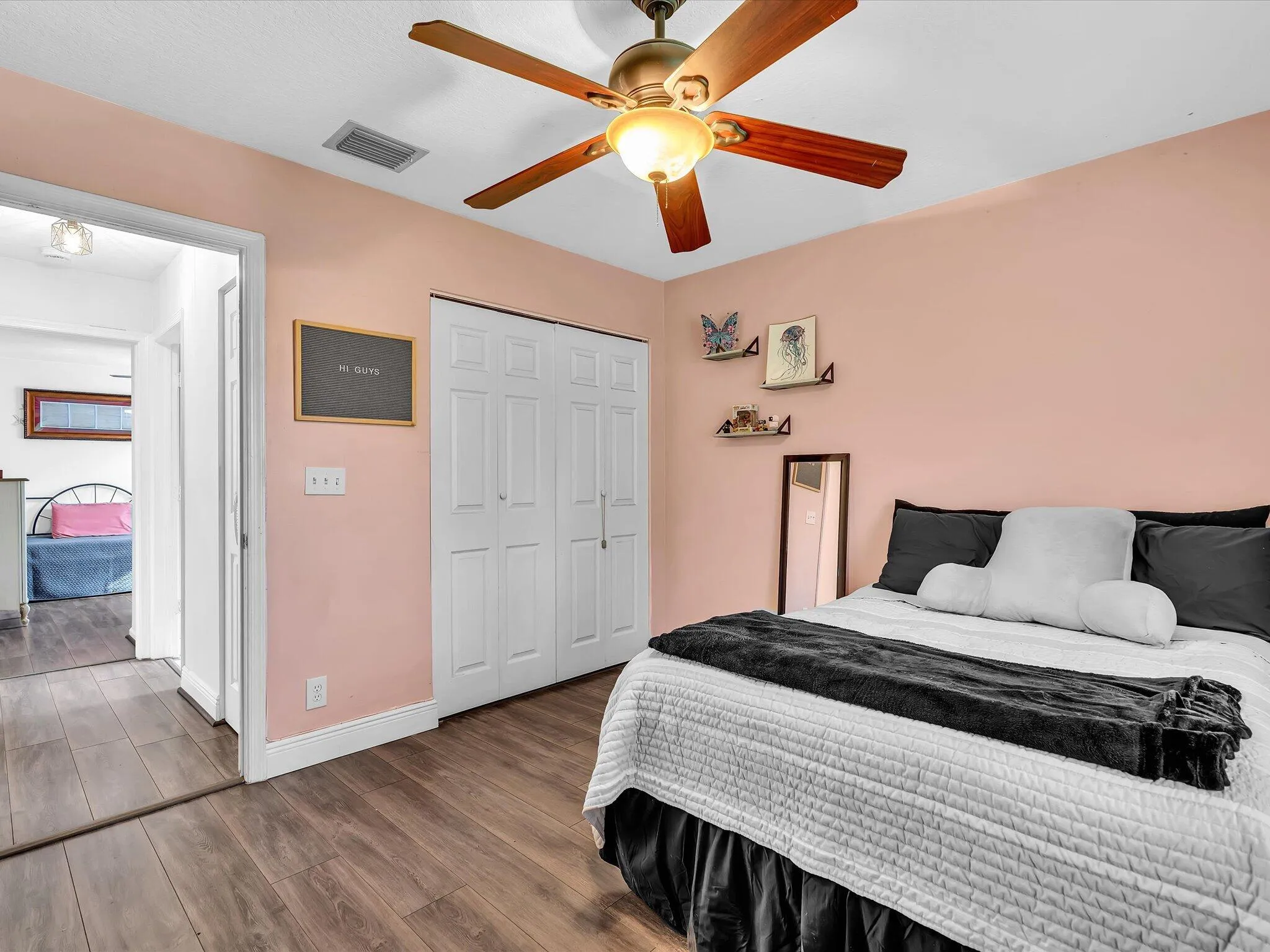 Wood-finish flooring throughout, ceiling fan with integrated lighting, and white bi-fold closet doors