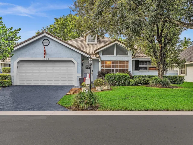 Front exterior featuring a two-car garage, tile roofing, and a prominent front entryway