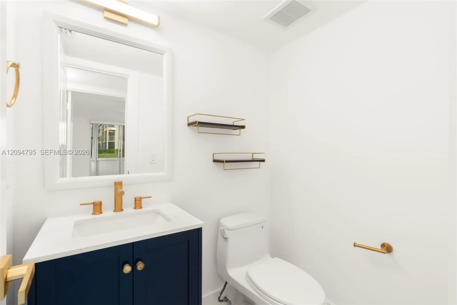 Updated guest bathroom with gold and blue accents.
