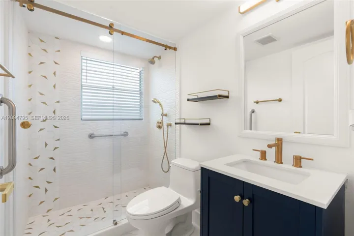 Primary bathroom with gold accents.