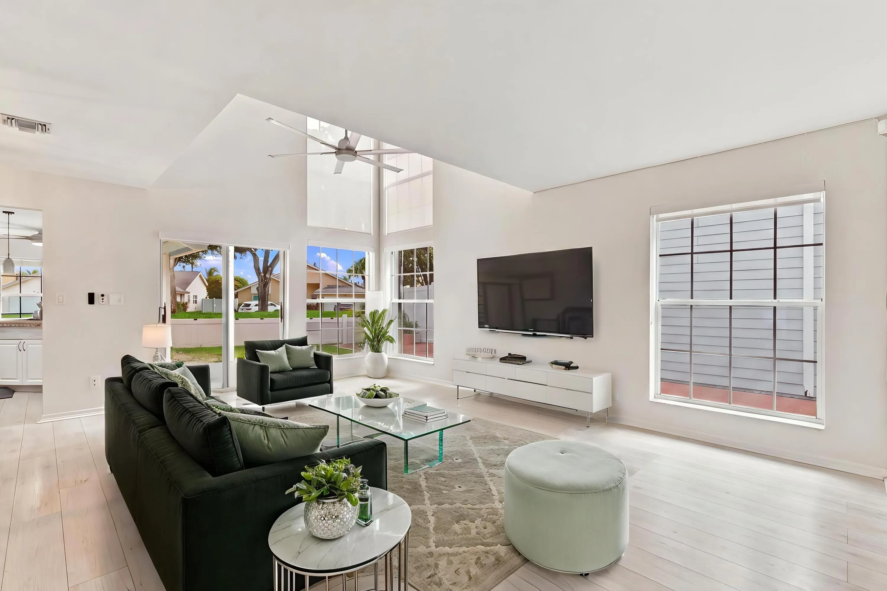 From the moment you enter, soaring ceilings and expansive windows fill the home with natural light, creating a bright, welcoming atmosphere that immediately feels like home.