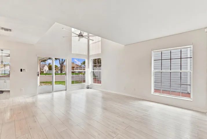 From the moment you enter, soaring ceilings and expansive windows fill the home with natural light, creating a bright, welcoming atmosphere that immediately feels like home.