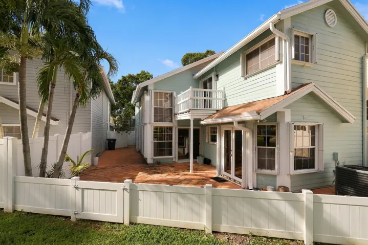 The private backyard is designed for effortless Florida living, featuring an expansive Spanish tile patio with a covered area for year-round enjoyment. A brand-new white PVC fence provides a secure space for pets while preserving views of the surrounding green spaces and mature trees. Perfect for barbecues, entertaining, and relaxed indoor-outdoor living.