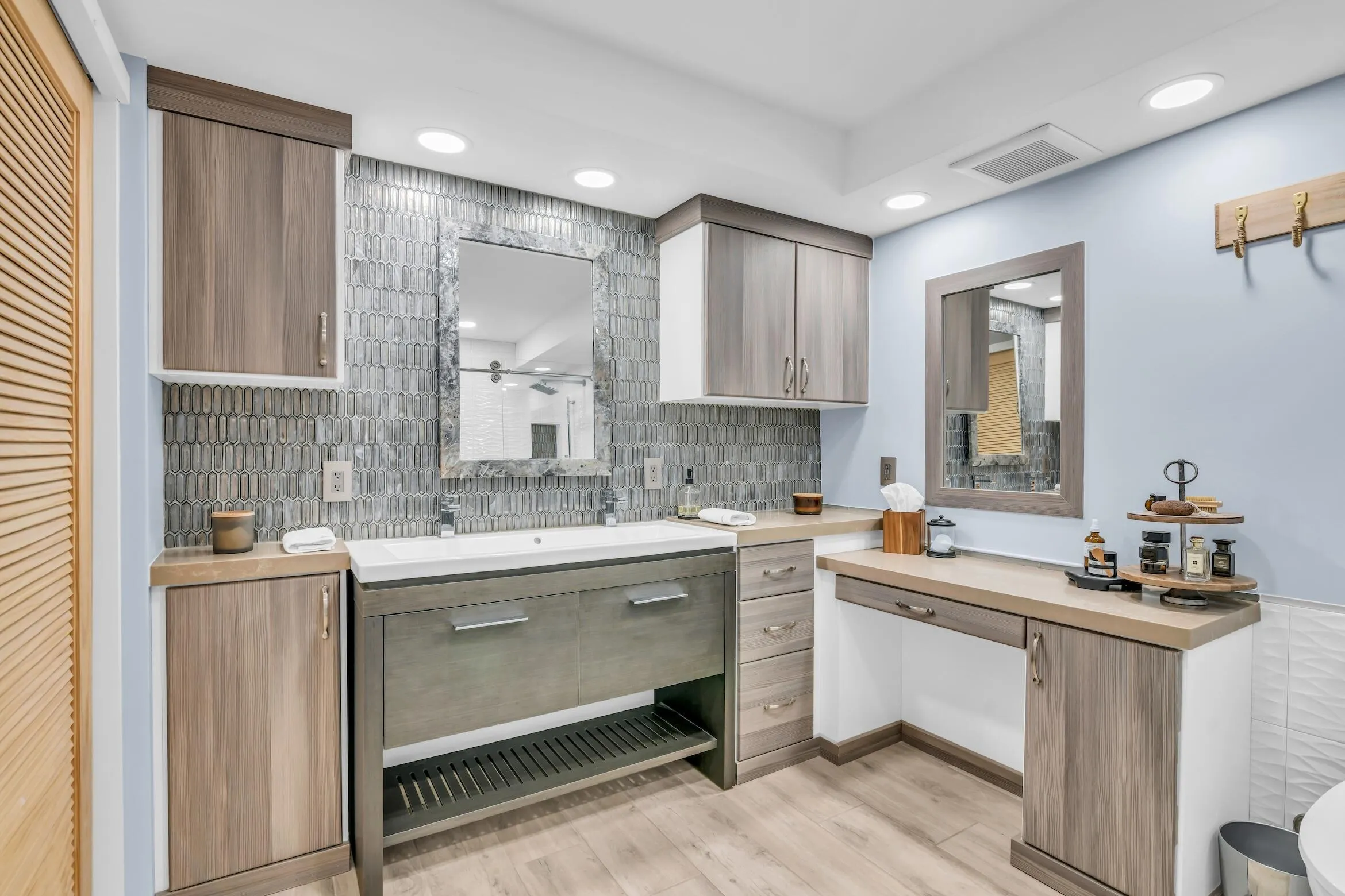 Primary bathroom with beuatiful decorative tile detail and separate vanity and custom build-in mirror