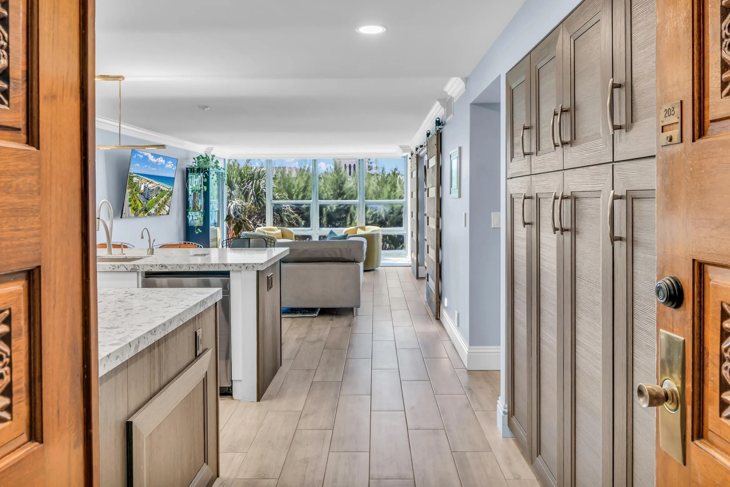 Double door entrance to the unit. High ceilings and glass walls allow natural light to flood the living​​‌​​​​‌​​‌‌​‌‌​​​‌‌​‌​‌​‌​​​‌​​ space