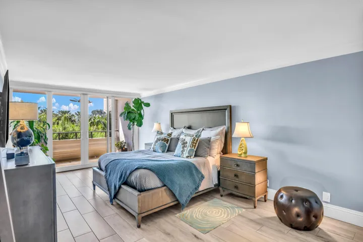 Huge primary bedroom with ample space for a sitting area opens to the balcony and has hidden motorized blackout shade