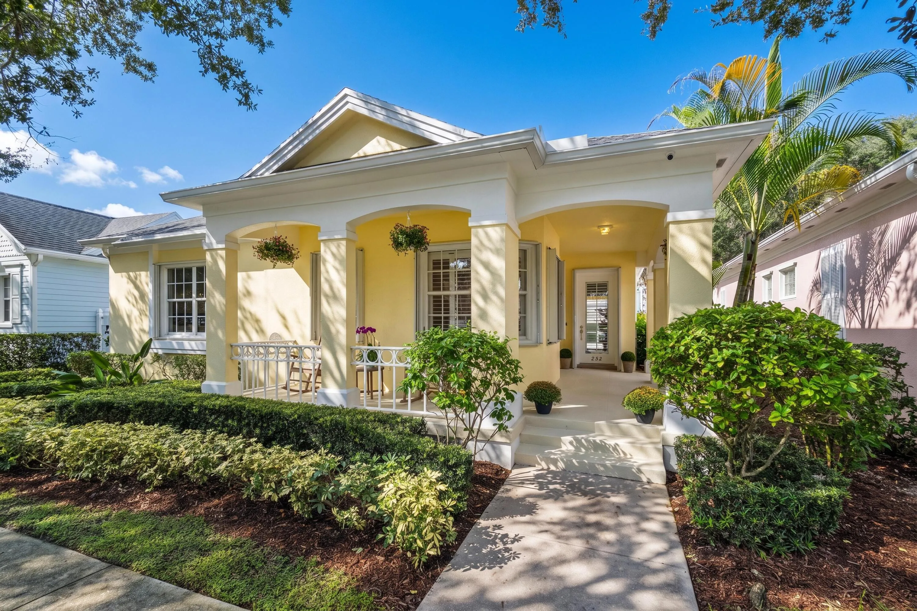 Front elevation with arched colonnade, welcoming front steps and manicured landscaping