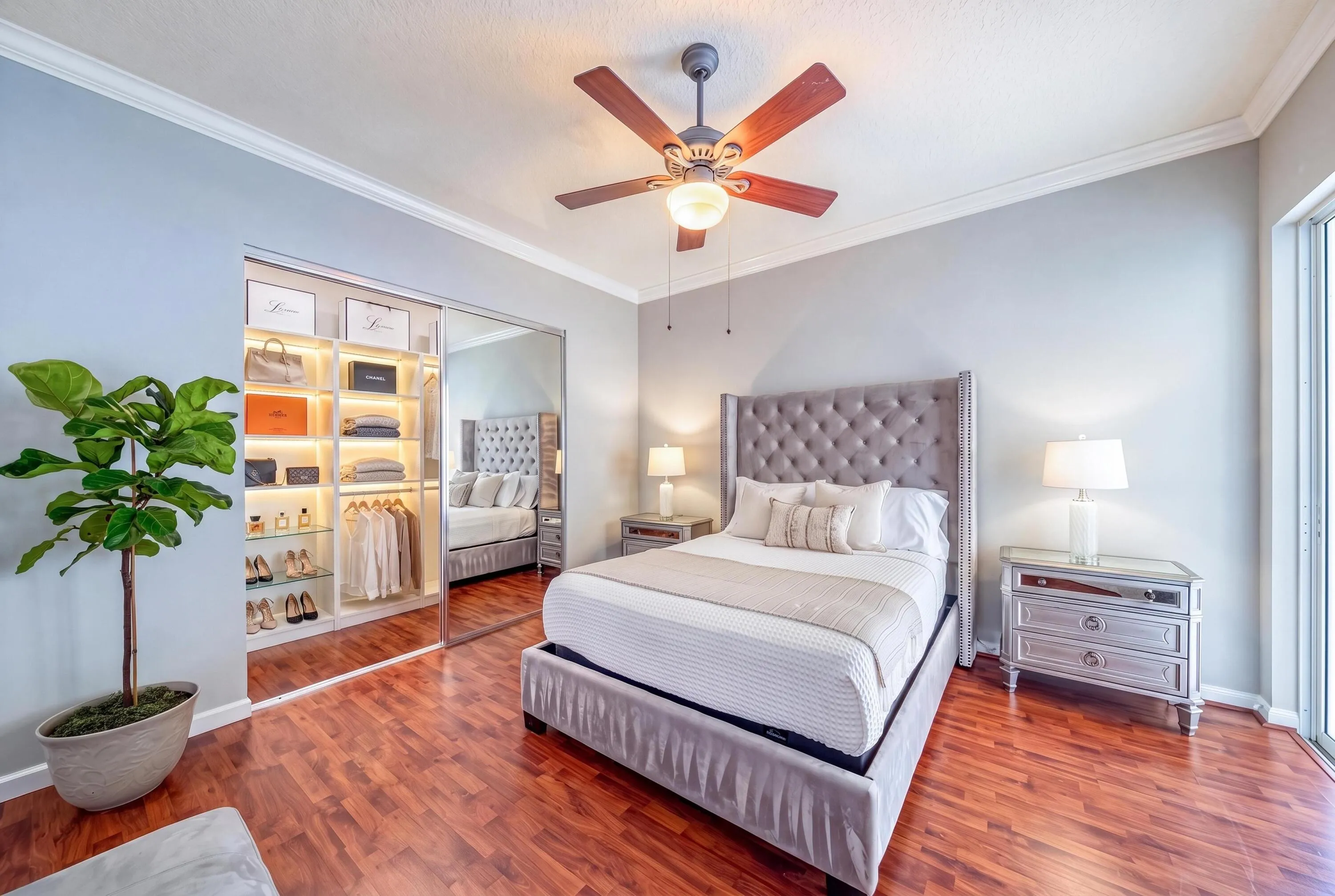 Primary bedroom with open custom closet and screened patio access (closet virtually staged)
