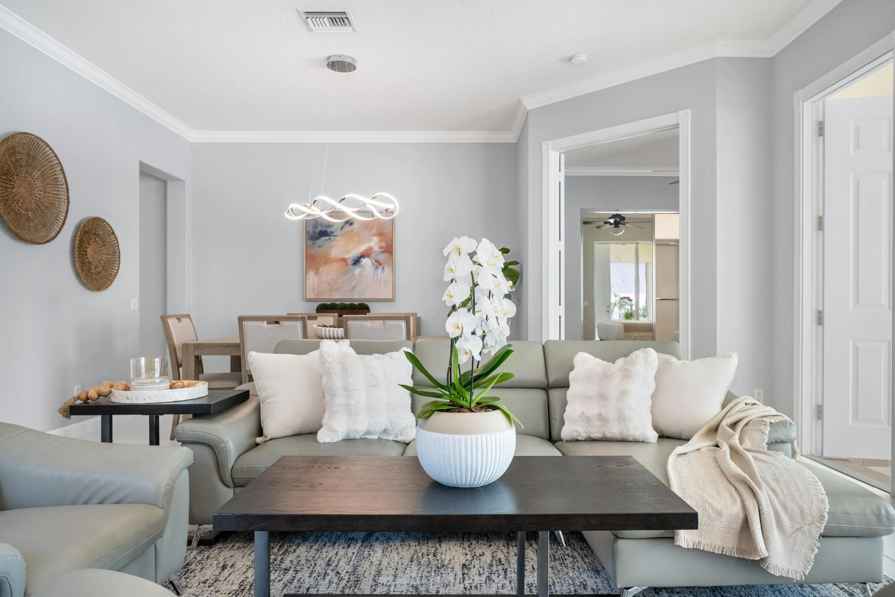 Living room and dining room with double doors opening to the primary suite