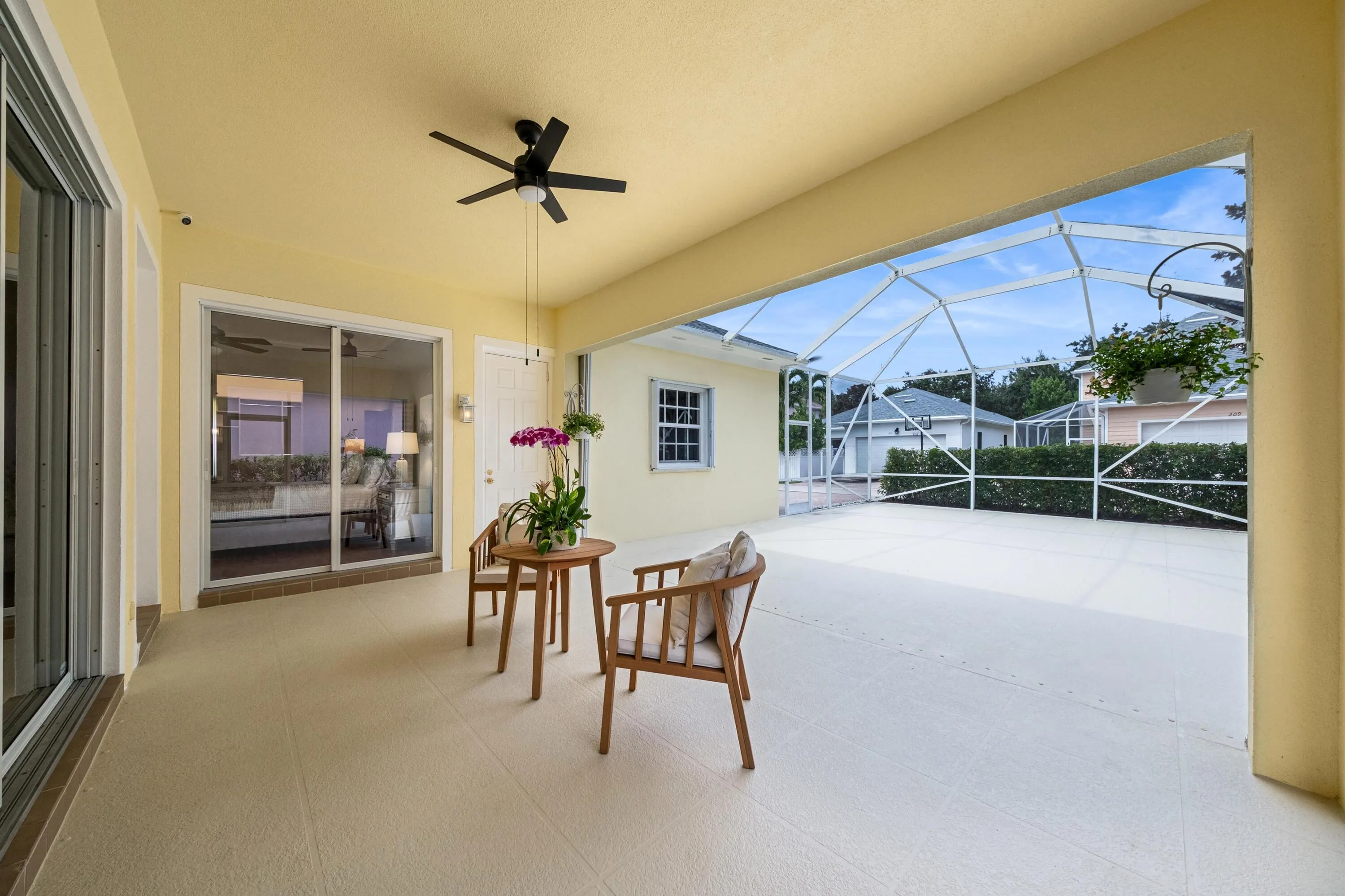 Covered end of the screened patio, with sliders to the living room and primary suite