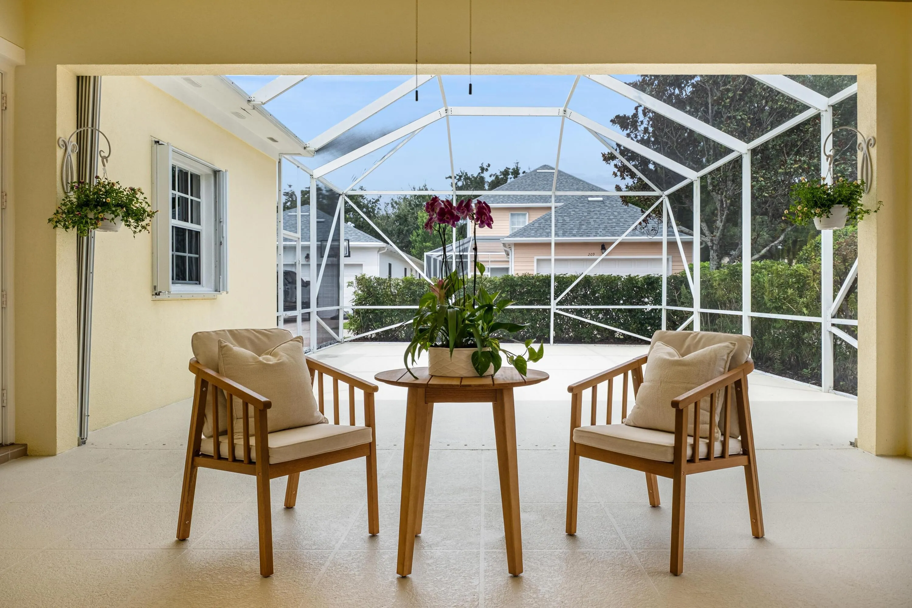 Covered seating area with a framed view across the screened patio