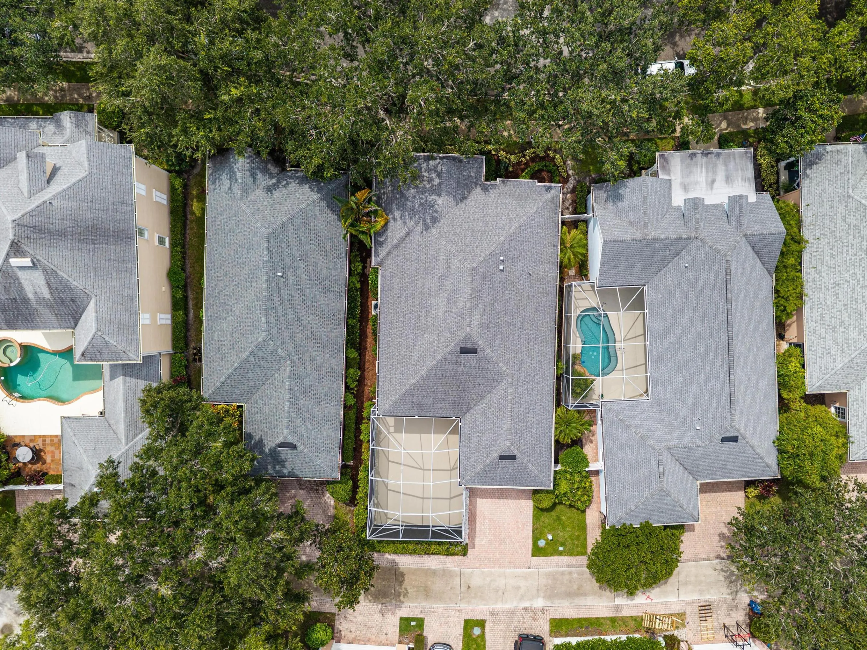 Close overhead aerial of the roofline, screened patio and landscaped side yard