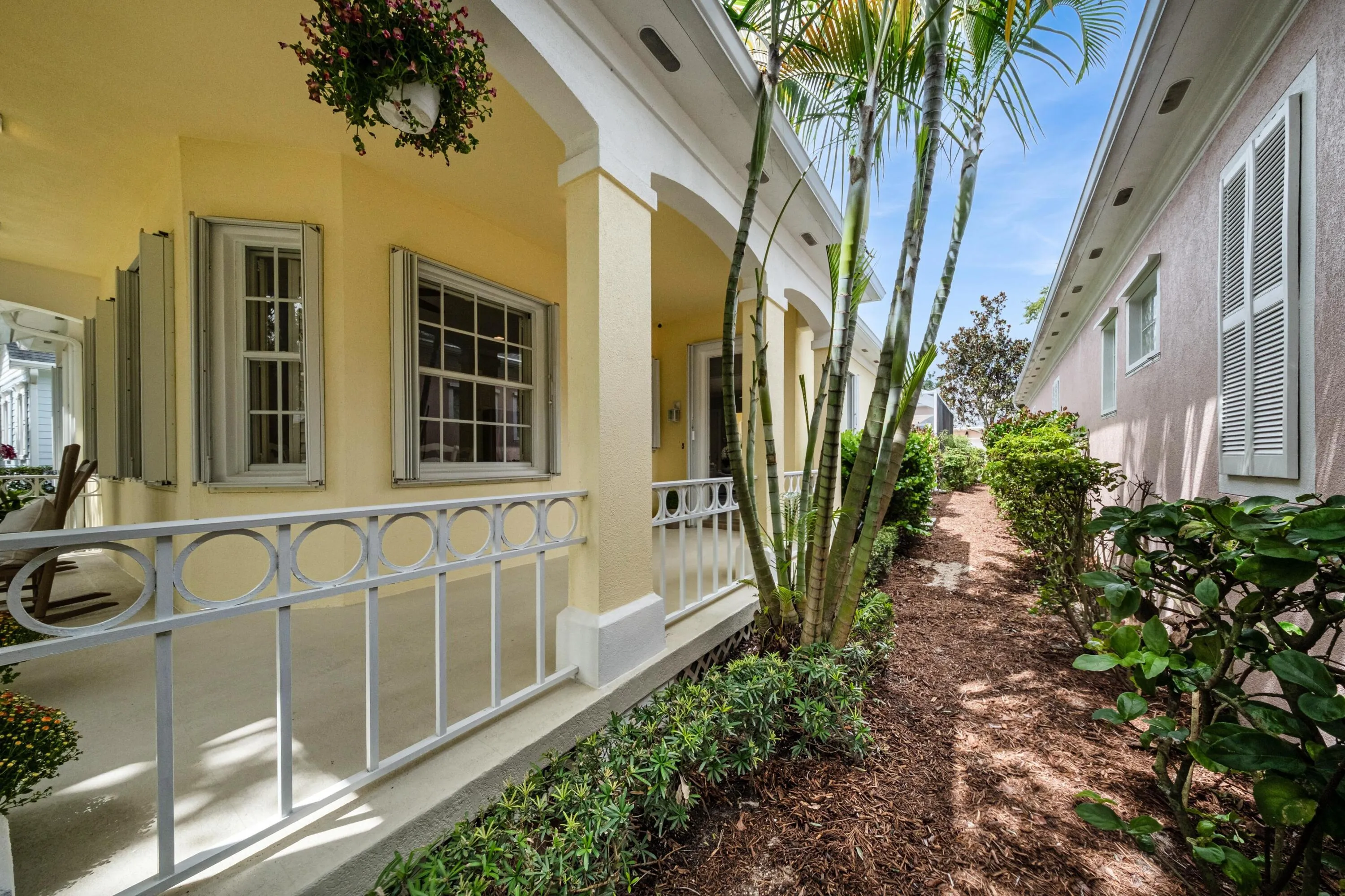 Covered front porch detail with circle-motif railings and a landscaped side garden path