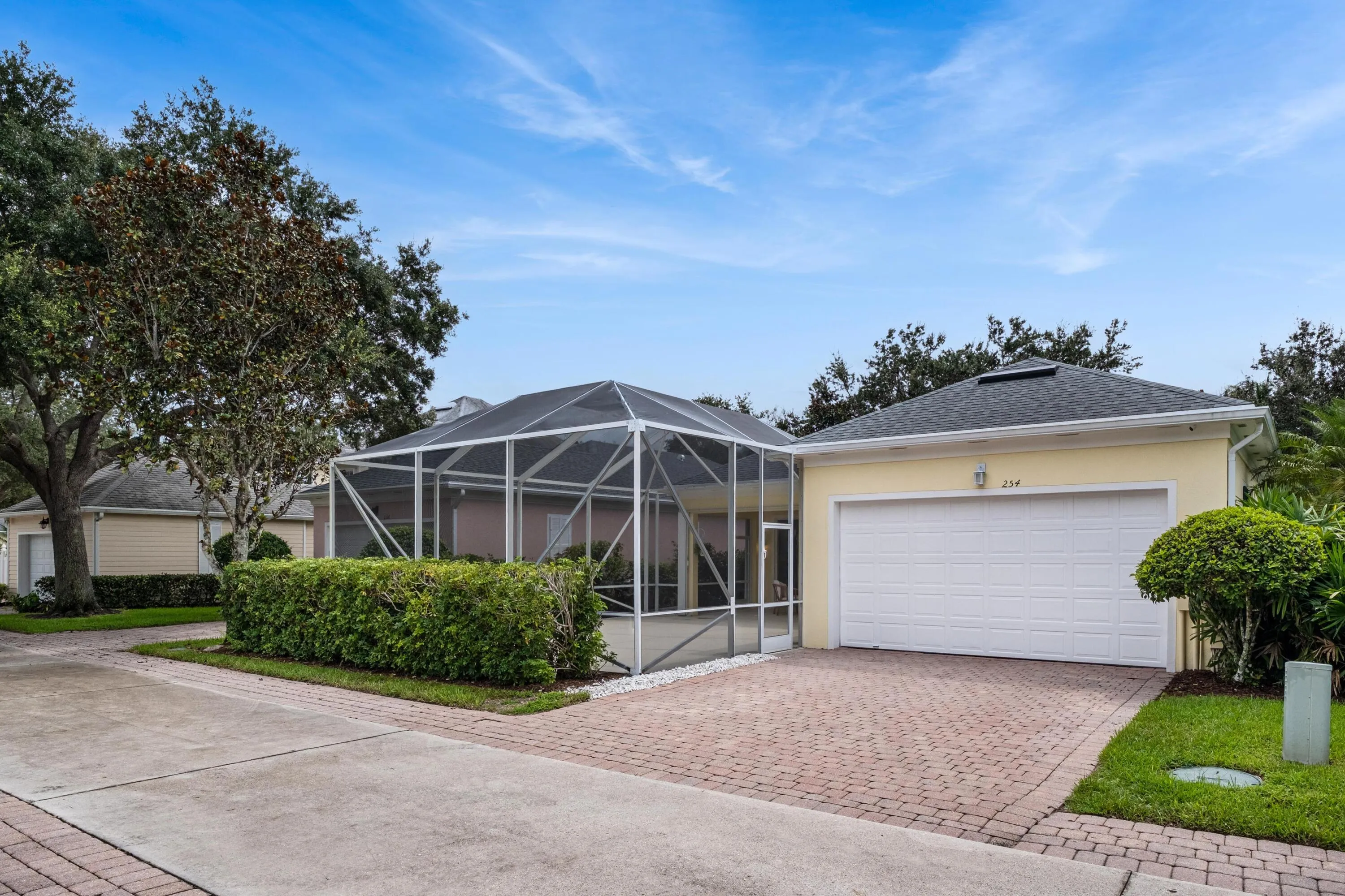 Rear-loaded two-car garage on a paver lane, beside the screened patio