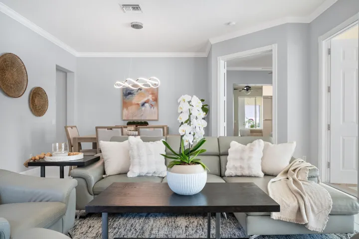 Living room and dining room with double doors opening to the primary suite