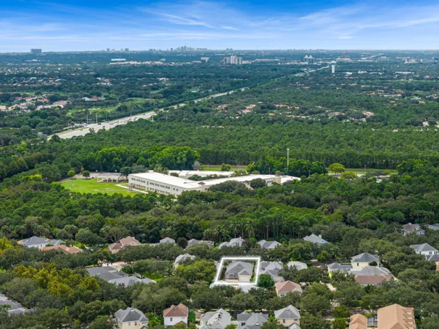 Aerial with the residence outlined amid mature oaks and nearby preserve land