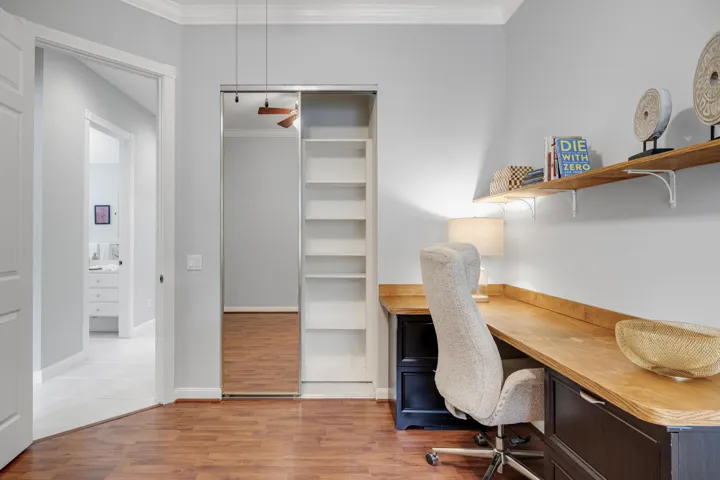 Bedroom closet with built-in shelving, with the bathroom just across the hall
