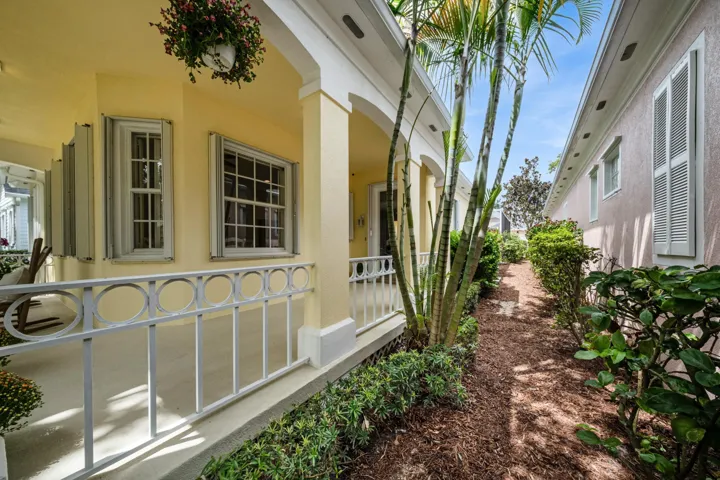 Covered front porch detail with circle-motif railings and a landscaped side garden path