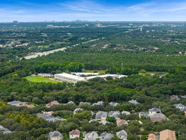 Aerial over mature oaks and preserve land toward the distant skyline