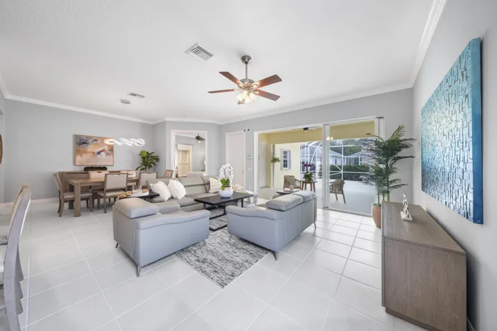 Spacious living room with the dining room behind and sliding glass doors to the covered and screened patio