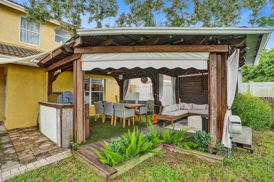 Covered outdoor living area with a wood-framed pergola and built-in bar