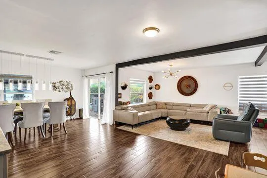 Open concept living and dining area with wood-finish flooring