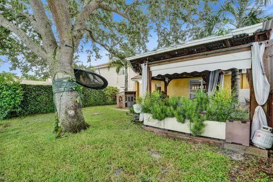 Expansive outdoor living area featuring a wood pergola and a shade awning