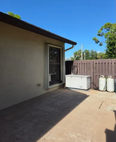 Concrete patio with stucco exterior and white window trim