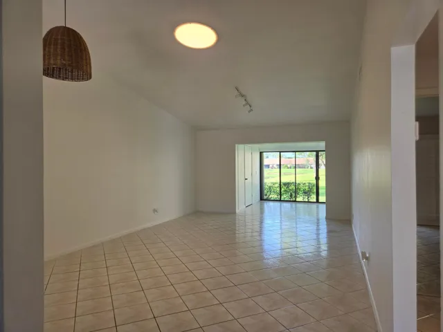 Tiled flooring throughout, vaulted ceiling, recessed lighting, and a sliding glass door