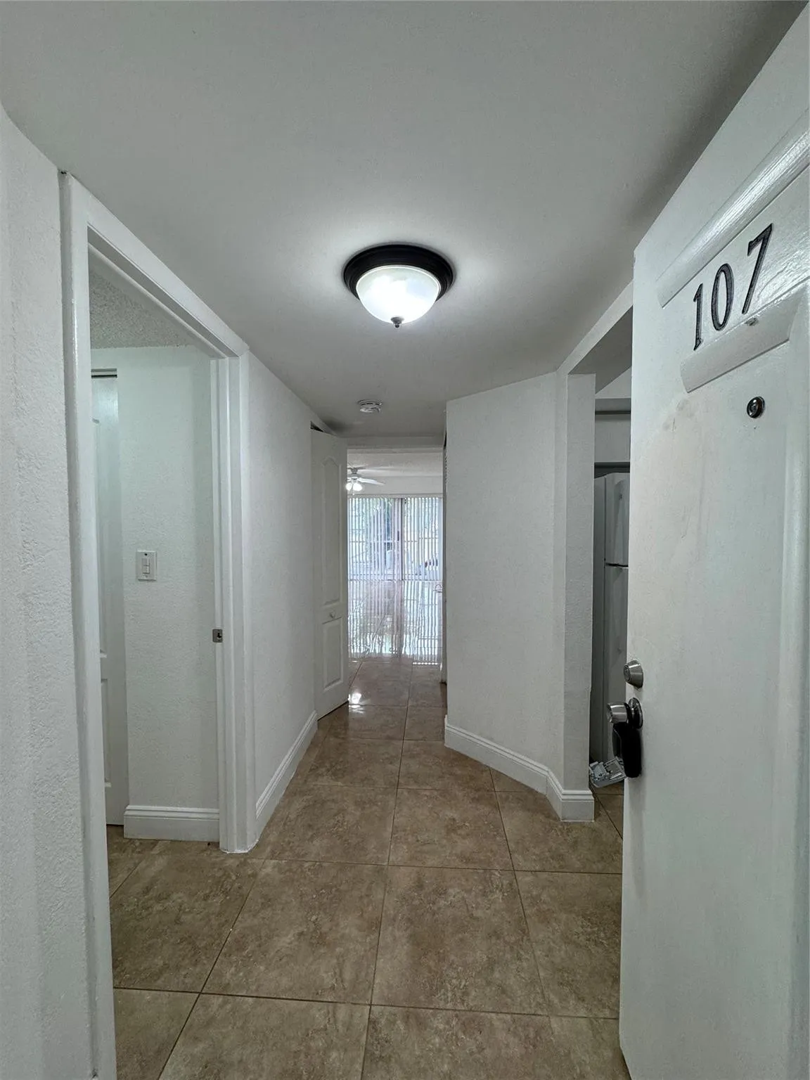 Tiled flooring throughout, white walls, and a ceiling-mounted light fixture