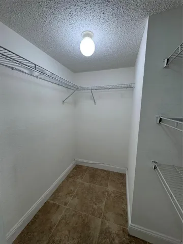 Recessed closet with tile flooring and wire shelving