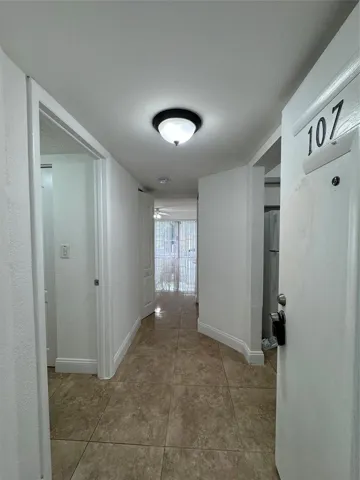Tiled flooring throughout, white walls, and a ceiling-mounted light fixture