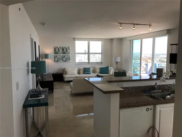 View of partial kitchen, dining and living room.