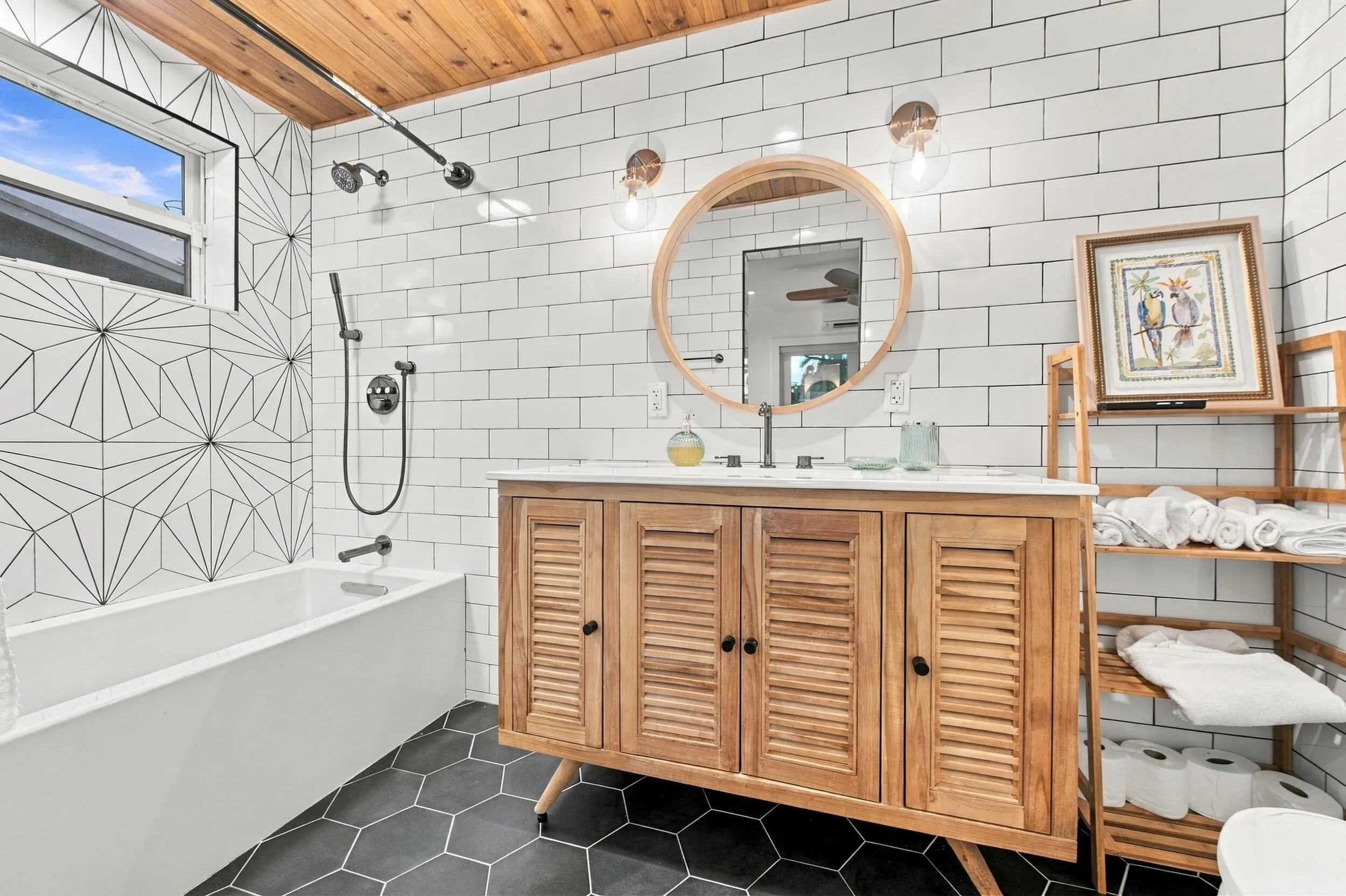 Wood-finish ceiling, white subway tile walls, geometric pattern shower wall tile, deep soaking tub, and hexagon floor tiling