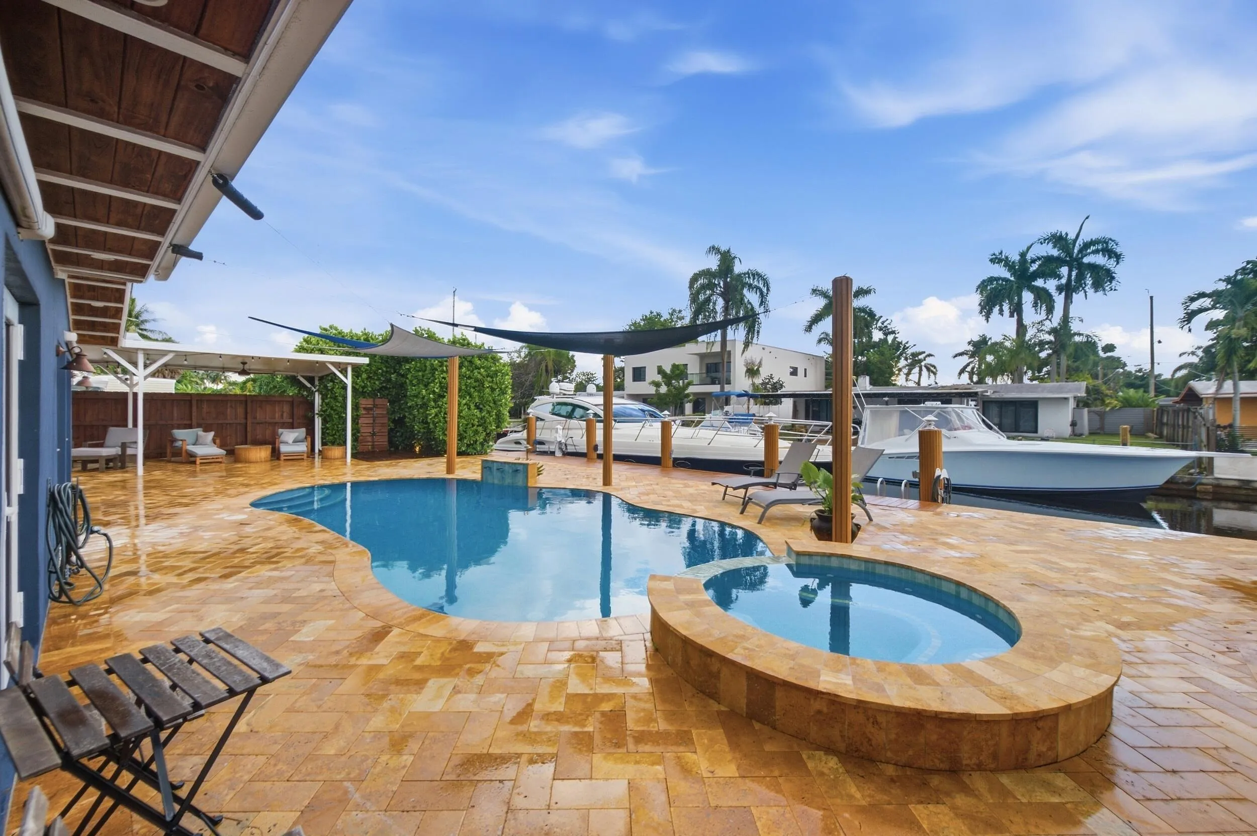 Freeform swimming pool with integrated spa and extensive paver patio