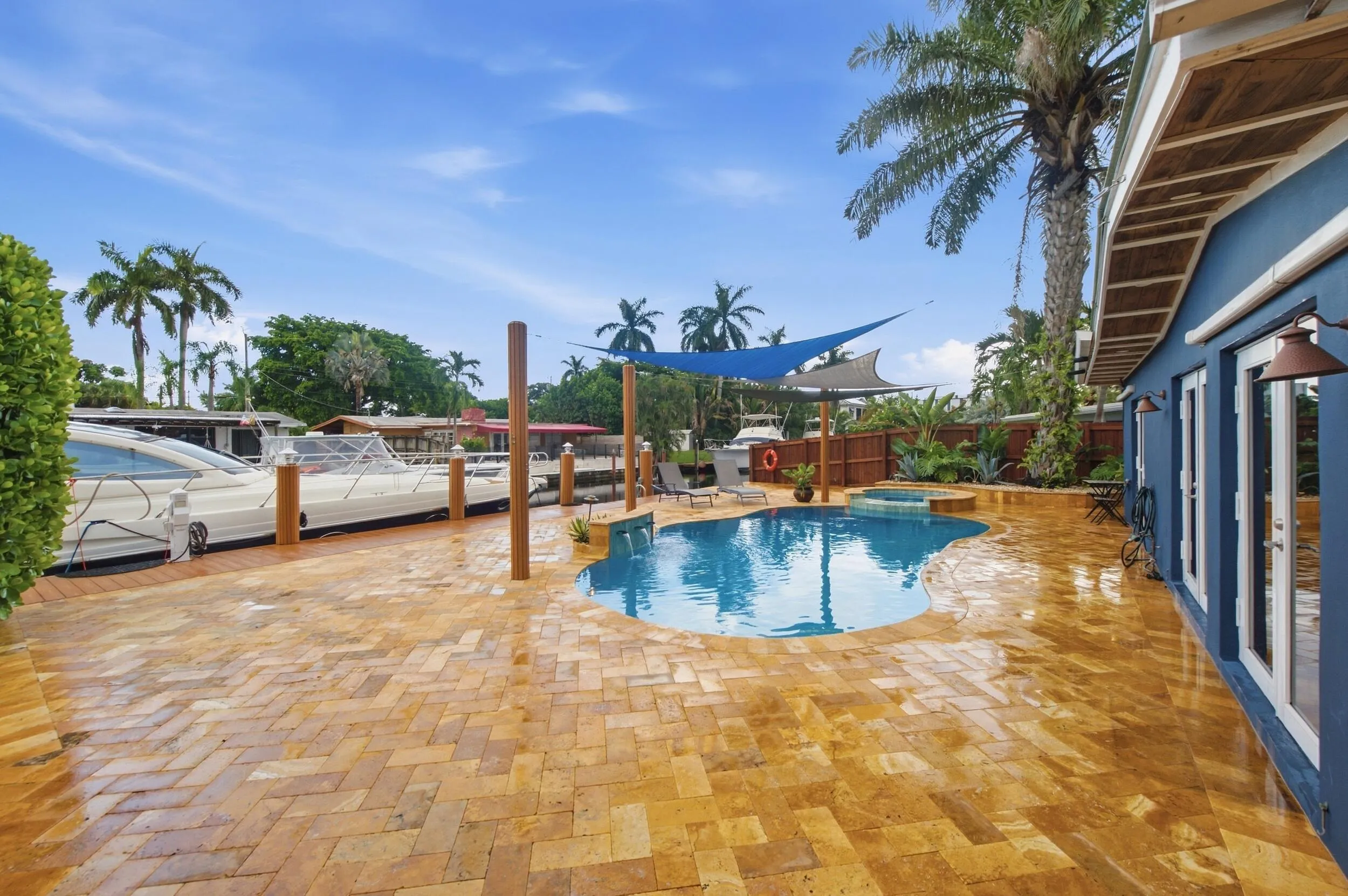Freeform pool, surrounding patio, and waterfront access with dock