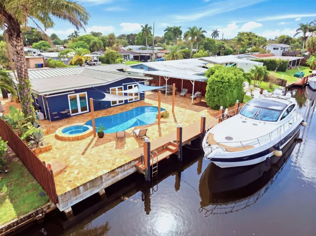 Waterfront property featuring a private dock, swimming pool, and integrated spa