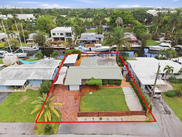 Aerial perspective highlighting the property's waterfront location, private boat dock, and surrounding canal